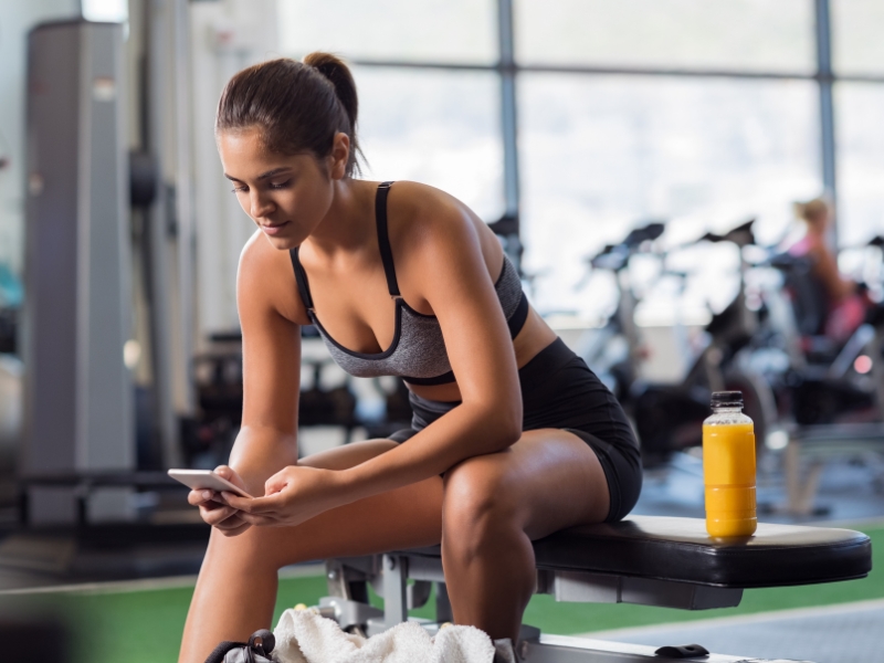 woman using a smartphone in her gym