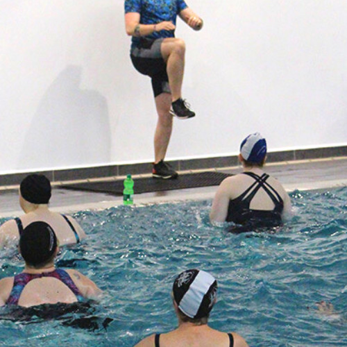 people in a swimming pool attending an aquafitness class