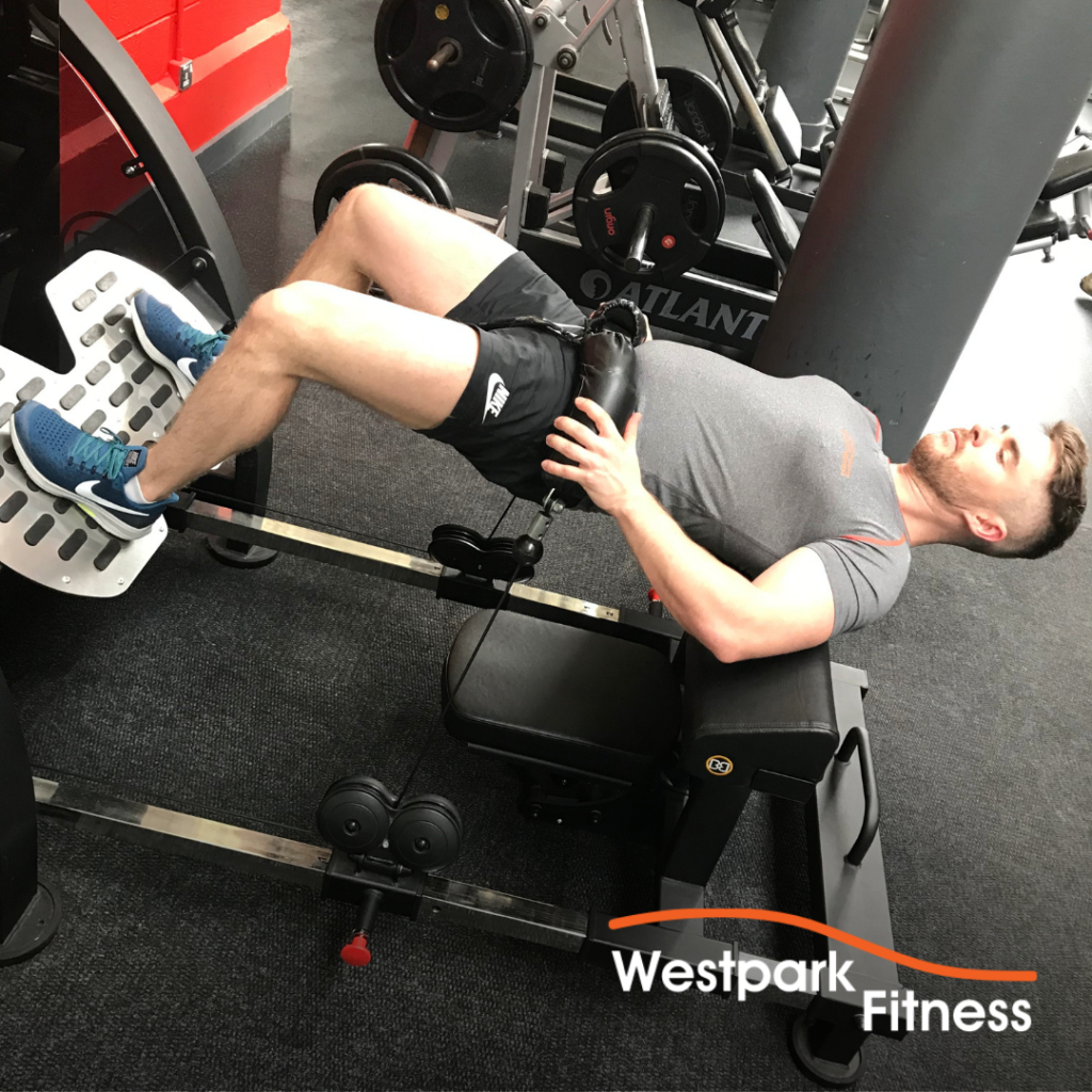 booty builder machine at westpark fitness male gym goer lying on the machine with body raised in the air