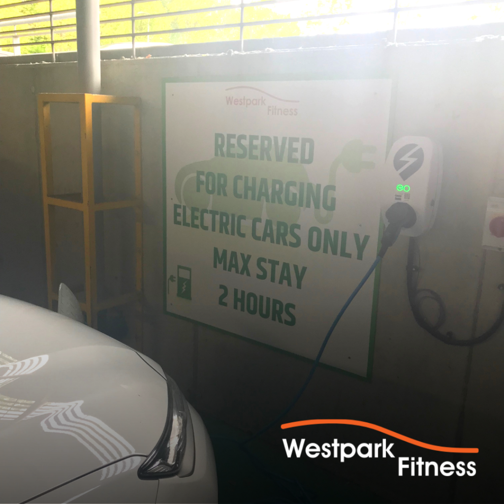 environmentally friendly gym in dublin electric car charger station with front of white car visibly plugged into it