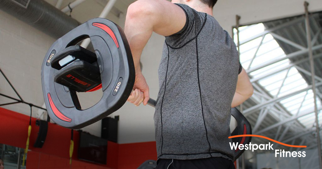 grip and forearm builder man in gym holding a barbell with two hands