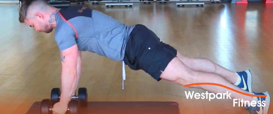 westpark fitness renegade row exercise showing a male gym goer lying on a gym mat holding two dumbbells