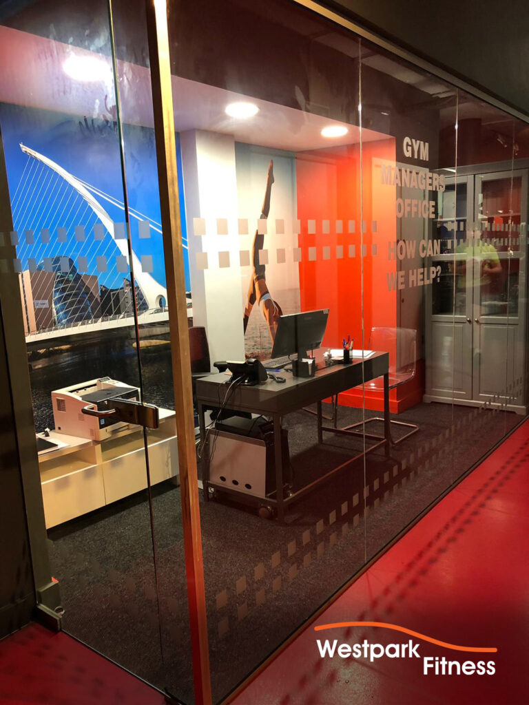 choose westpark fitness glass wall of gym managers office showing desk and chair and computer