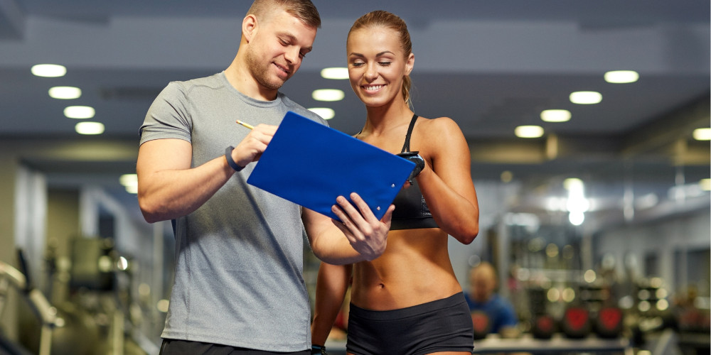 man showing woman her rewards at the gym